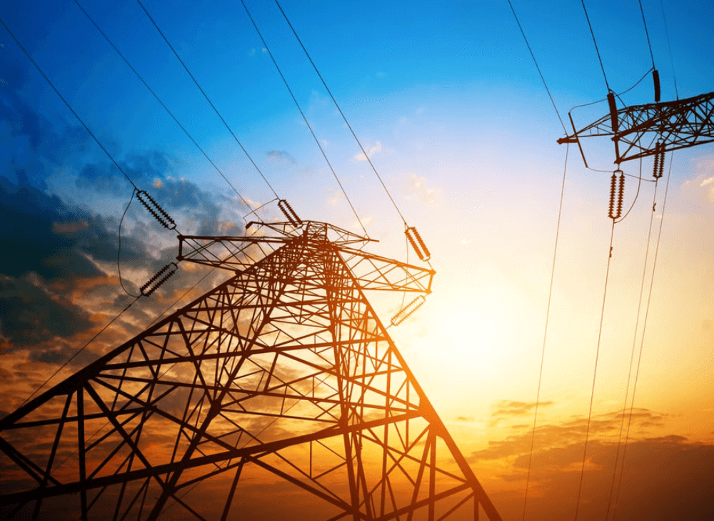 Transmission towers under cloudy skies during dawn